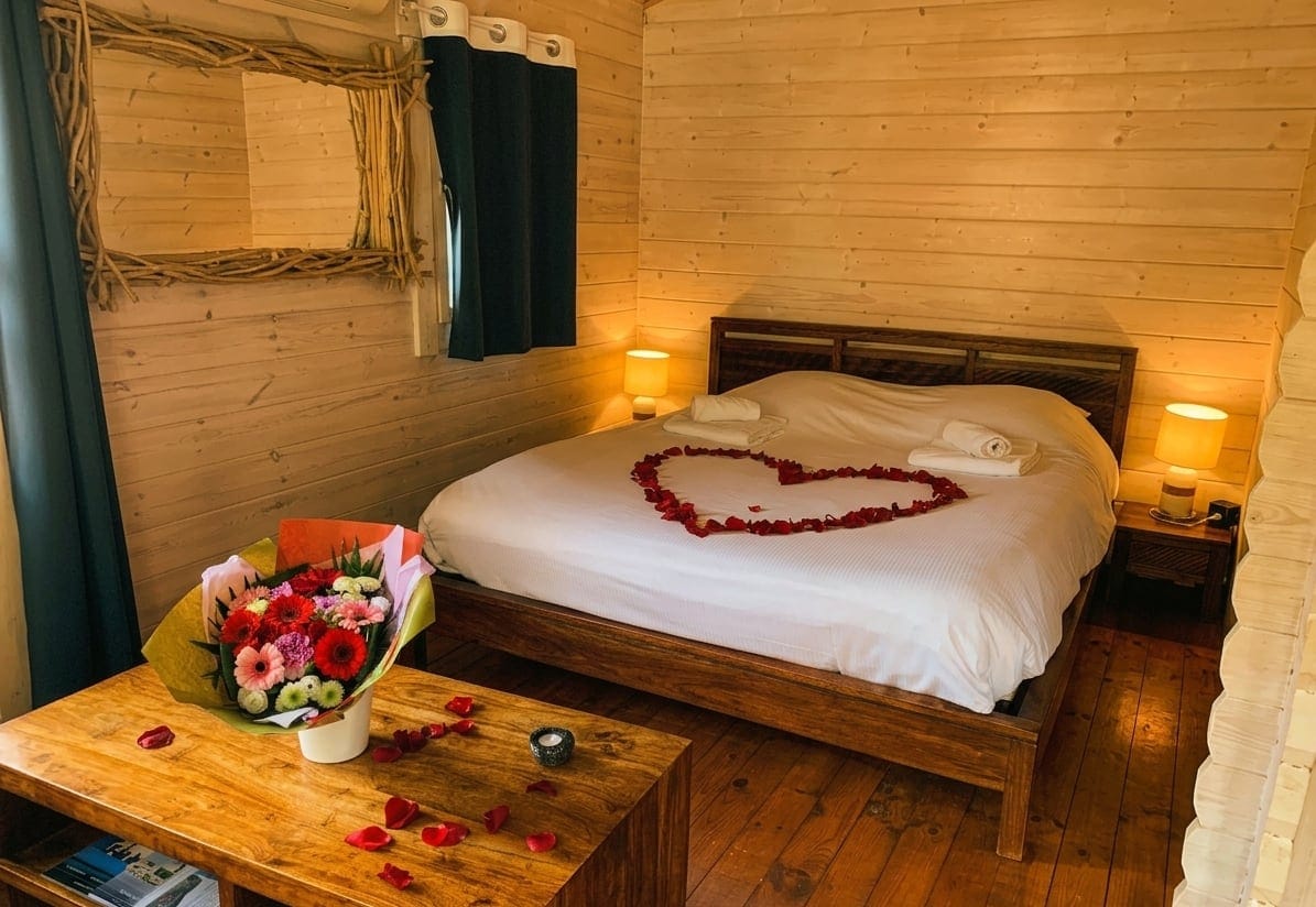 Chambre Love Room aux pétales de roses — chalet flottant romantique en Gironde